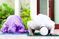 Asian Muslim couple, man and woman, praying at home