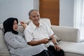 Asian muslim couple mature sitting couch relaxed when enjoy television