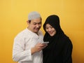 Asian muslim couple shocked or surprised to see something on smart phone, happy expression winning gesture Royalty Free Stock Photo