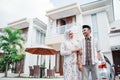 Asian Muslim couple smiling intimately with hands holding