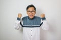 Asian muslim man holding smartphone doing winning gesture, Happy get special gift online, isolated on white background