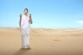 Asian Muslim man in ihram clothes standing and praying while raised arms Royalty Free Stock Photo