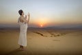 Asian Muslim man in ihram clothes standing and praying while raised arms Royalty Free Stock Photo