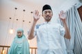 Asian Muslim man leads prayers with woman saying Allahu Akbar