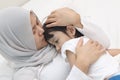 Asian muslim mother hijab calming her sad and crying daughter, single mom and baby girl together Royalty Free Stock Photo