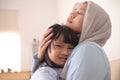 Asian muslim mother hijab calming her sad and crying daughter, single mom and baby girl together Royalty Free Stock Photo