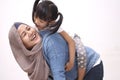 Asian muslim mother playing with her little baby girl daughter sit on her back, acting like a horse for her kid, happy smiling Royalty Free Stock Photo