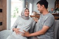 Muslim pregnant woman with her husband sitting