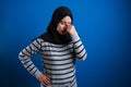 Asian muslim teenage girl holding her head and close her eyes, painful expression Royalty Free Stock Photo