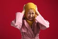 Asian muslim teenage girl wearing hijab, screaming losing temper, cant control emotions, close eyes and ears while yelling