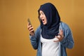 Asian muslim woman angry by phone call, screaming on her phone Royalty Free Stock Photo