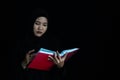 Asian Muslim woman in black Muslim veil hijab reading the Qur'an Royalty Free Stock Photo