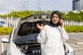 asian muslim woman broken car have a problem on road. Female trying fix their car and calling to motor mechanic and calls Royalty Free Stock Photo