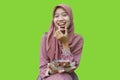 asian muslim woman eating dates during iftar with green background