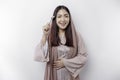 An Asian Muslim woman is fasting and hungry and holding cutlery while looking aside thinking about what to eat Royalty Free Stock Photo