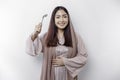 An Asian Muslim woman is fasting and hungry and holding cutlery while looking aside thinking about what to eat Royalty Free Stock Photo