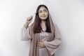 An Asian Muslim woman is fasting and hungry and holding cutlery while looking aside thinking about what to eat Royalty Free Stock Photo