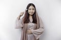 An Asian Muslim woman is fasting and hungry and holding cutlery while looking aside thinking about what to eat Royalty Free Stock Photo