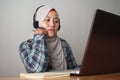 Asian muslim woman having video teleconference on her laptop at home, online learning or working from home