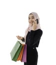 Asian muslim woman in hijab standing talking by smartphone and hold shopping bag isolated on white background with clipping path