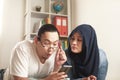 Asian muslim woman looked jelaous of her husband man doing chat with other girl on phone, bad couple relationship