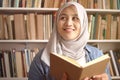 Asian muslim woman thinking while reading book, education concept, learning studying in library Royalty Free Stock Photo