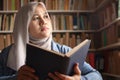 Asian muslim woman thinking while reading book, education concept, learning studying in library Royalty Free Stock Photo