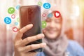 Asian muslim woman using phone with social media icons, digital media internet communication concept Royalty Free Stock Photo