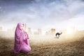 Asian Muslim woman in veil sitting and praying with prayer beads on her hands Royalty Free Stock Photo