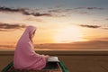Asian Muslim woman in a veil sitting and reading the Quran Royalty Free Stock Photo