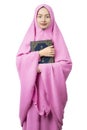 Asian Muslim woman in a veil standing and holding the Quran Royalty Free Stock Photo