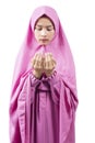 Asian Muslim woman in a veil standing while raised hands and praying Royalty Free Stock Photo