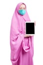 Asian Muslim woman in a veil and wearing a flu mask showing a blank tablet screen Royalty Free Stock Photo