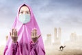 Asian Muslim woman in a veil and wearing flu mask standing while raised hands and praying Royalty Free Stock Photo