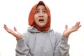 Asian muslim woman wearing hijab stuned shocked expression looking up with big eyes and open mouth, expecting something bad from