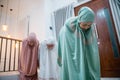 Asian Muslim women in muslim clothes doing ruku prayer movements