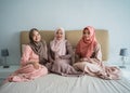 Asian muslimah woman enjoy chatting while sitting on the bed