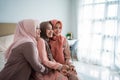 Asian muslimah woman enjoy chatting while sitting on the bed