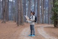 Asian naturalist looking at the map for direction while exploring wildlife in the pine forest for surveying and discovering the Royalty Free Stock Photo