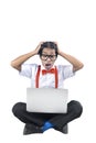 Asian nerd with ugly face sitting while using a laptop with shocked expression Royalty Free Stock Photo