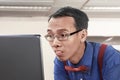 Asian nerdy businessman working using laptop