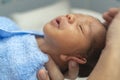 Asian newborn baby boy is feeling comfortable and sleepy after taking bath at the first time of life. mother or father closing Royalty Free Stock Photo