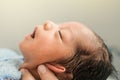 Asian newborn baby boy is feeling relaxed and sleepy after taking bath at the first time of life. mother or father closing ears of Royalty Free Stock Photo