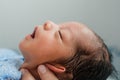 asian newborn baby boy is feeling relaxed and sleepy after taking bath at the first time of life. mother or father closing ears of Royalty Free Stock Photo