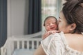 Asian newborn baby with mother on the bed. Mom holding and kissing her child Royalty Free Stock Photo