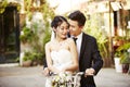 Asian newly wed couple riding a bicycle