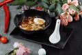 Asian noodle soup, ramen with chicken, tofu, vegetables and egg in black bowl. Slate background Royalty Free Stock Photo