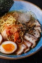 Asian noodle soup, ramen with pork, tofu, kimchi, vegetables and egg in blue bowl. Slate background. Top view. Bowl of Royalty Free Stock Photo