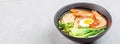 Asian noodle soup, ramen with prawn shrimp, vegetables and egg in black bowl on gray concrete background. Flat lay, Top view, mock Royalty Free Stock Photo