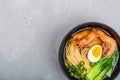 Asian noodle soup, ramen with prawn shrimp, vegetables and egg in black bowl on gray concrete background. Flat lay, Top view, mock Royalty Free Stock Photo